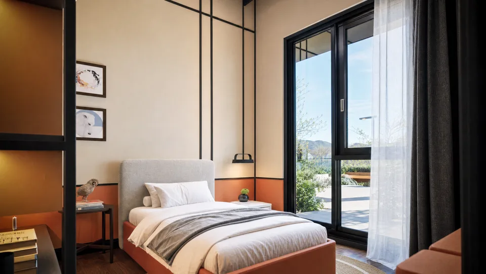 Panoramic interior of a show unit living and dining space with pale timber floors and sheer curtains.