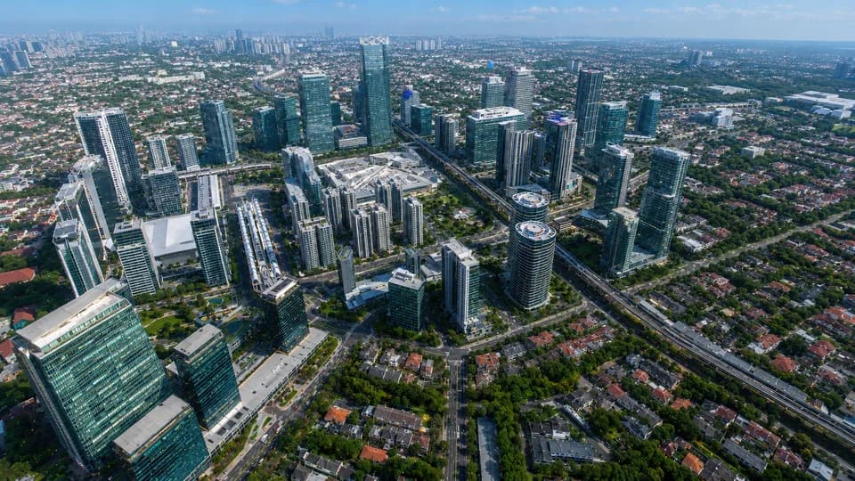 Aerial frame from an urban precinct flythrough showing boulevards, civic buildings and open parkland.